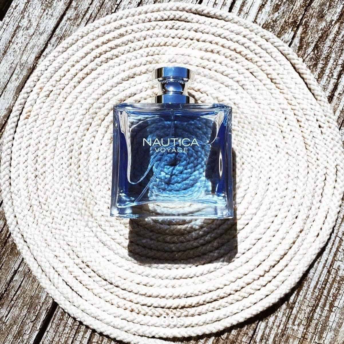 a bottle of nautica voyage on top of a rolled rope