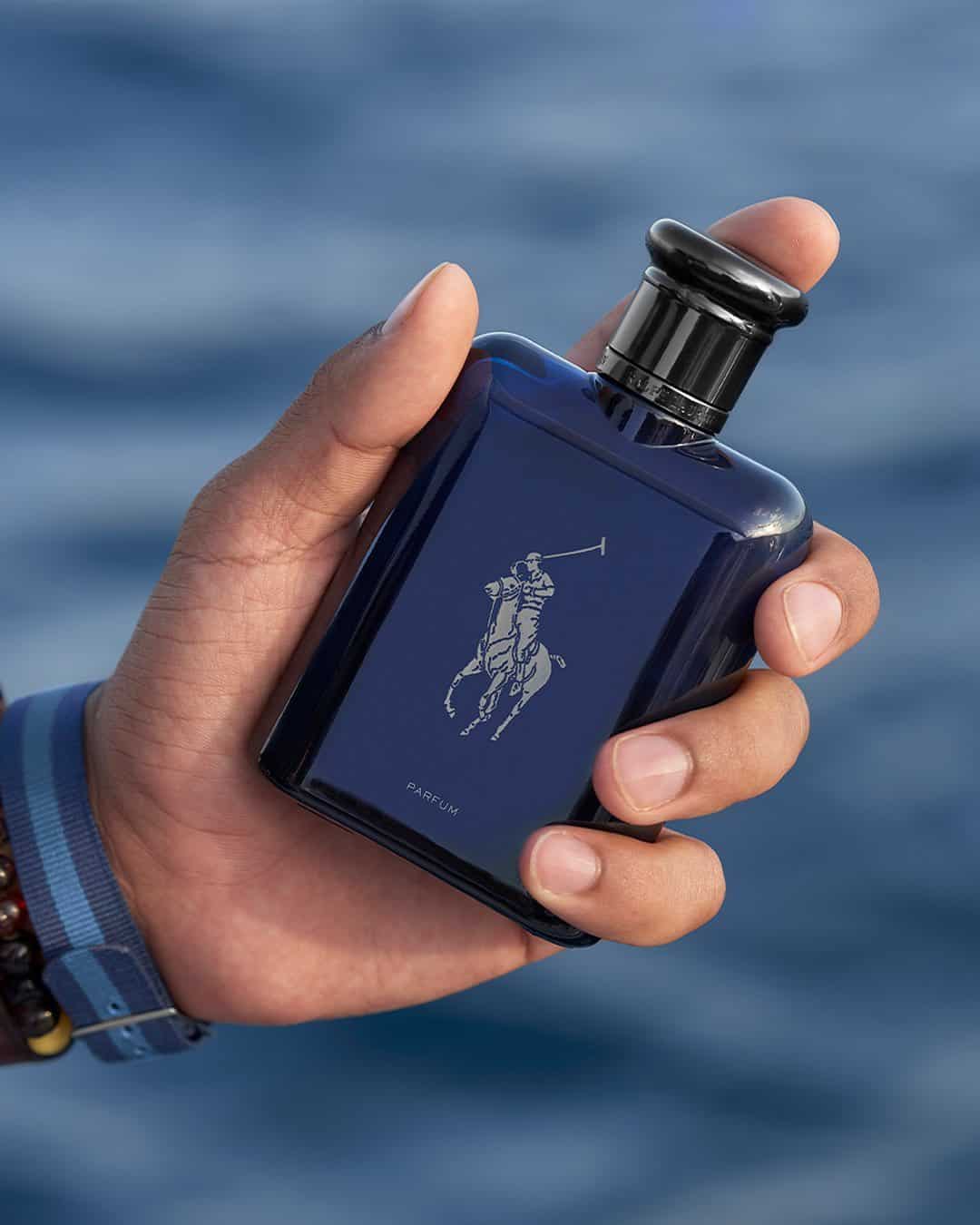 holding a bottle of blue parfum by polo