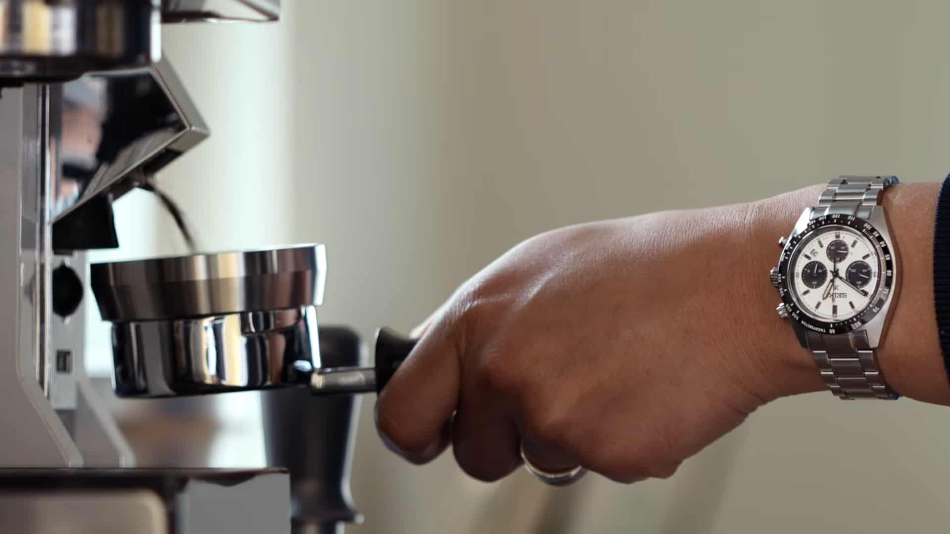 showing off the Seiko SSC813 on wrist working an espresso machine